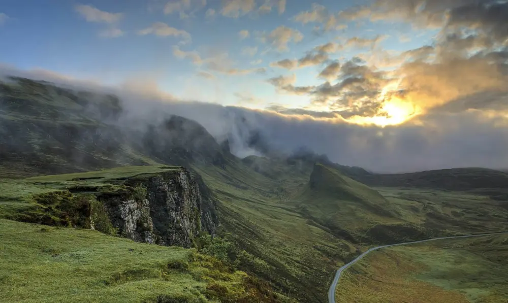 Sun through mist over a mountain valley
